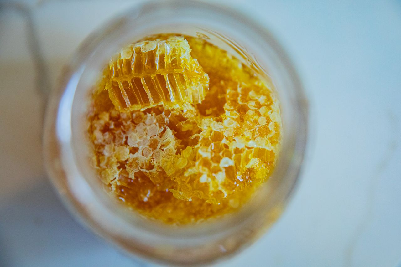 why-choose-us Close-up view of fresh honeycomb pieces in a jar, showcasing natural sweetness and texture.